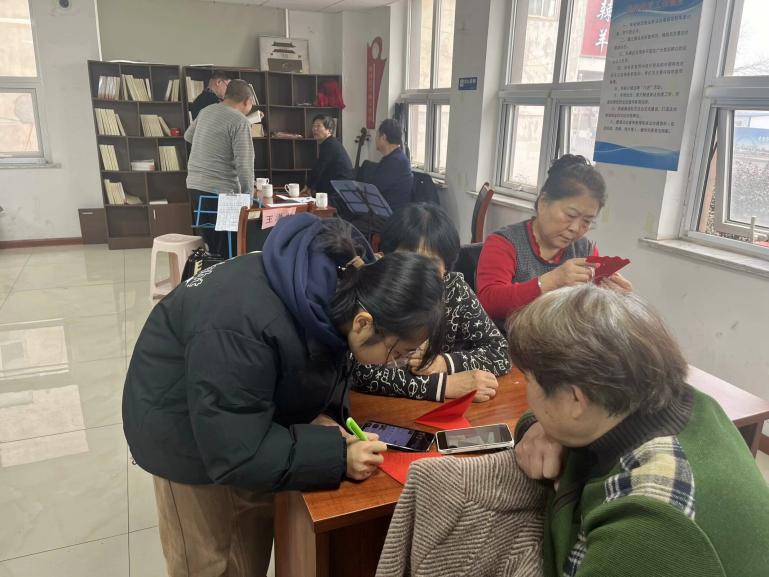 手把手教學(xué)深入社區(qū)，心連心剪紙再頌新風(fēng)